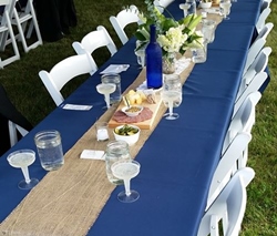 Banquet table with blue tablecloth and place settings